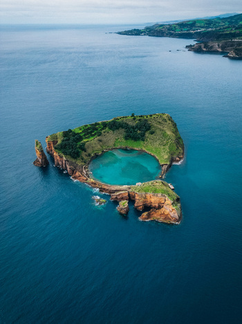 Aerial view of Vila Franca Islet a volcanic crater with a natural pool surrounded by the deep blue Atlantic Vila Franca do Campo Azores Portugal.