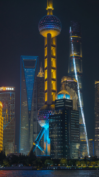Aerial view of the illuminated Oriental Pearl Tower and the modern skyscrapers of the Lujiazui financial district at night in Shanghai Shanghai China.