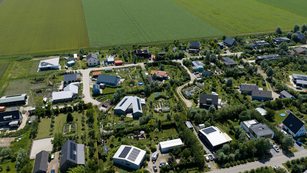 Aerial view of Ecodorp Bolderburen featuring sustainable modern houses with solar panels lush gardens and green spaces surrounded by agricultural fields in Almere Flevoland Netherlands. Aerial view of Ecodorp Bolderburen featuring sustainable modern houses with solar panels lush gardens and green spaces surrounded by agricultural fields in Almere Flevoland Netherlands.