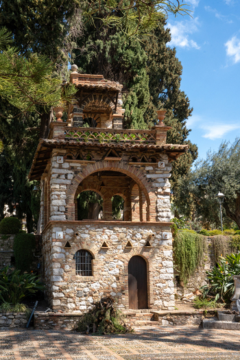 View of an ancient stone structure amidst lush greenery bathed in sunlight a testament to time and nature s embrace Taormina Sicily Italy.