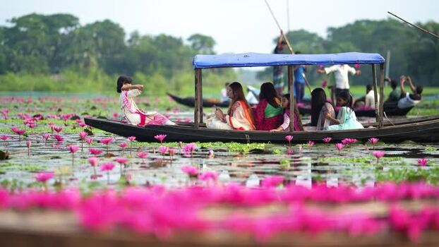 View of people in a boat on a water lily lake Bangladesh. View of people in a boat on a water lily lake Bangladesh.