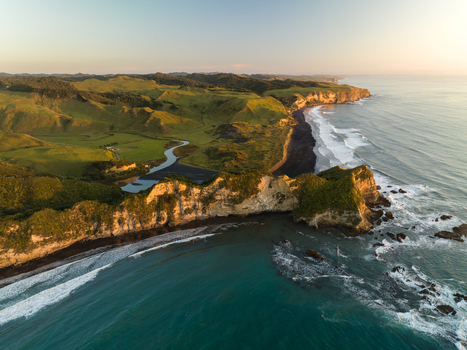 Aerial view of the rugged Waikawau coastline where emerald hills meet the dark sands and turquoise waters Waikawau Waikato Region New Zealand. Aerial view of the rugged Waikawau coastline where emerald hills meet the dark sands and turquoise waters Waikawau Waikato Region New Zealand.