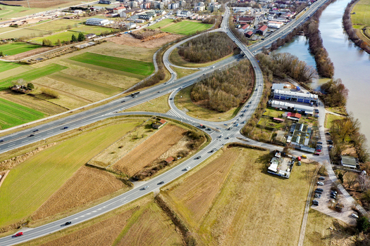 Aerial view of a highway interchange surrounded by agricultural fields and industrial buildings near a river in Forchheim Bavaria Germany. Aerial view of a highway interchange surrounded by agricultural fields and industrial buildings near a river in Forchheim Bavaria Germany.