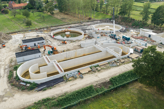 Diepenbeek Flanders Belgium 30 August 2026 Aerial view of a wastewater treatment plant under construction featuring concrete tanks excavators and surrounding rural landscape. Diepenbeek Flanders Belgium 30 August 2026 Aerial view of a wastewater treatment plant under construction featuring concrete tanks excavators and surrounding rural landscape.