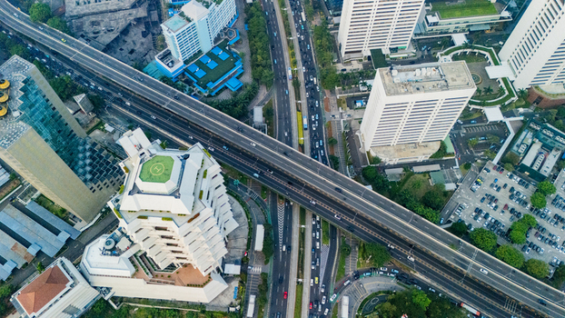 Aerial view of a busy highway intersection with modern skyscrapers and office buildings in the central business district of Jakarta Indonesia.