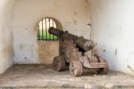 View of an ancient iron cannon on a wooden carriage inside a stone alcove at the historic Galle Fort in Galle Southern Province Sri Lanka.