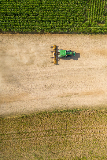 Aerial view of a tractor tilling dry soil in the Knoblauchsland agricultural area next to green crop fields Nuremberg Bavaria Germany. Aerial view of a tractor tilling dry soil in the Knoblauchsland agricultural area next to green crop fields Nuremberg Bavaria Germany.