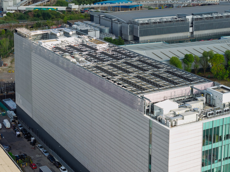 Aerial view of a large data center with rooftop cooling units and industrial infrastructure in the United Kingdom. Aerial view of a large data center with rooftop cooling units and industrial infrastructure in the United Kingdom.