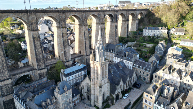 Aerial view of the Eglise Saint Melaine de Morlaix and the massive stone arches of the Morlaix Viaduct overlooking historic rooftops in Morlaix Bretagne France. Aerial view of the Eglise Saint Melaine de Morlaix and the massive stone arches of the Morlaix Viaduct overlooking historic rooftops in Morlaix Bretagne France.