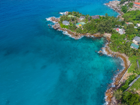 Aerial view of the rugged coastline where turquoise waters meet the verdant land creating a stunning contrast of colors and textures Vista do Mar Mahe Island Seychelles. Aerial view of the rugged coastline where turquoise waters meet the verdant land creating a stunning contrast of colors and textures Vista do Mar Mahe Island Seychelles.