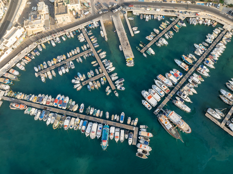 Aerial view of boats docked in Mgarr Harbour where turquoise waters meet the man made structures creating a tapestry of maritime activity Mgarr Harbour Gozo Malta. Aerial view of boats docked in Mgarr Harbour where turquoise waters meet the man made structures creating a tapestry of maritime activity Mgarr Harbour Gozo Malta.