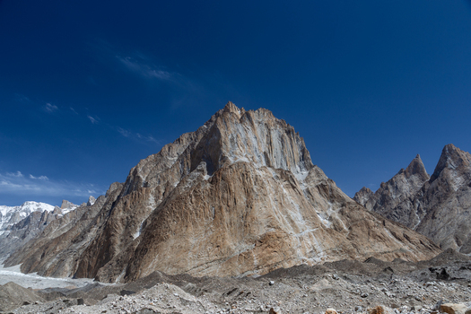 View of Baltoro Glacier surrounded by rugged mountain peaks under a clear blue sky in Baltoro Gilgit Baltistan Pakistan.