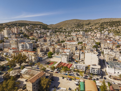 Aerial view of the coastal city of Saranda featuring dense urban architecture a central sports court and surrounding hills in Saranda Vlore County Albania. Aerial view of the coastal city of Saranda featuring dense urban architecture a central sports court and surrounding hills in Saranda Vlore County Albania.