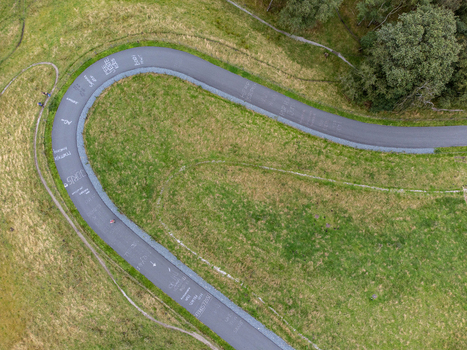 Aerial view of Col du Vam a winding cycling road surrounded by lush green grassy hills and trees in Wijster Drenthe Netherlands. Aerial view of Col du Vam a winding cycling road surrounded by lush green grassy hills and trees in Wijster Drenthe Netherlands.