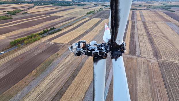 Aerial view of a destroyed wind turbine with a burnt nacelle and damaged blades standing above agricultural fields in Vladimirovac Vojvodina Serbia.