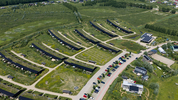 Aerial view of sustainable earth sheltered homes featuring green roofs and solar panels set within a landscaped residential area Almere Flevoland Netherlands. Aerial view of sustainable earth sheltered homes featuring green roofs and solar panels set within a landscaped residential area Almere Flevoland Netherlands.