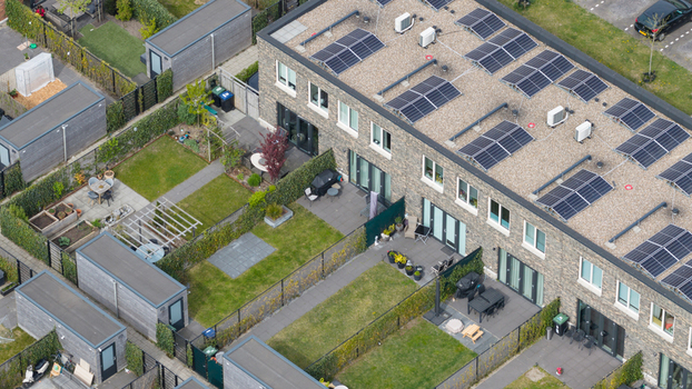 Aerial view of modern terraced houses in the Nobelhorst neighborhood featuring solar panels on flat roofs and private green gardens in Almere Flevoland Netherlands. Aerial view of modern terraced houses in the Nobelhorst neighborhood featuring solar panels on flat roofs and private green gardens in Almere Flevoland Netherlands.