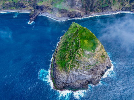 Aerial view of the verdant islet of Monchique dramatically contrasts with the deep blue sea a testament to nature s artistry Flores A&ccedil;ores Portugal.