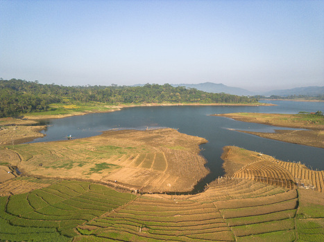 Aerial view of the Karanganyar reservoir surrounded by terraced agricultural fields and lush green hills in Wadaslintang Central Java Indonesia. Aerial view of the Karanganyar reservoir surrounded by terraced agricultural fields and lush green hills in Wadaslintang Central Java Indonesia.