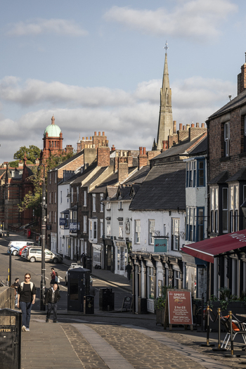 Durham United Kingdom 13 July 2026 View of historic Durham streets with traditional brick buildings a church spire and people walking on the sidewalk under a bright sky. Durham United Kingdom 13 July 2026 View of historic Durham streets with traditional brick buildings a church spire and people walking on the sidewalk under a bright sky.