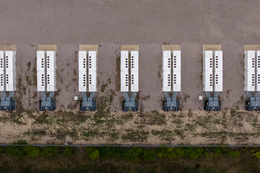 Aerial view of Chapel Farm Energy Park featuring rows of white battery storage units and electrical transformers on a gravel surface in Luton England United Kingdom. Aerial view of Chapel Farm Energy Park featuring rows of white battery storage units and electrical transformers on a gravel surface in Luton England United Kingdom.