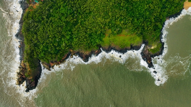Aerial view of the lush green coastline and rocky cliffs at Om Beach Birdview Point in Gokarna Karnataka India. Aerial view of the lush green coastline and rocky cliffs at Om Beach Birdview Point in Gokarna Karnataka India.