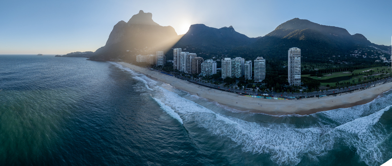 Aerial view of Sao Conrado beach with high rise residential buildings lush mountains and ocean waves crashing on the sand in Rio de Janeiro Rio de Janeiro Brazil.