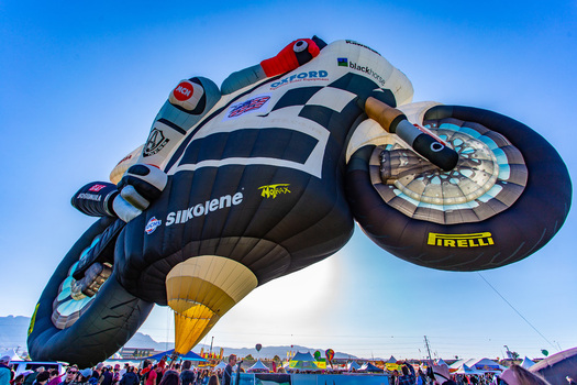 Albuquerque United States 09 October 2017 View of a motorcycle shaped hot air balloon soaring above a crowd its black and white design stark against the clear blue sky.