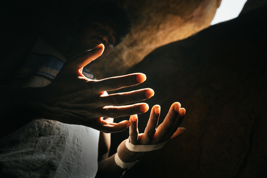 View of a person s hands illuminated by soft light inside a dark rocky cave in Hampi Karnataka India. View of a person s hands illuminated by soft light inside a dark rocky cave in Hampi Karnataka India.