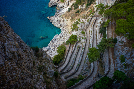 Aerial view of the winding stone path of Via Krupp carved into steep cliffs overlooking the turquoise Tyrrhenian Sea in Capri Campania Italy.