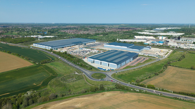 Aerial view of Symmetry Park industrial estate featuring large modern warehouses a busy roundabout and surrounding green fields in Kettering England United Kingdom. Aerial view of Symmetry Park industrial estate featuring large modern warehouses a busy roundabout and surrounding green fields in Kettering England United Kingdom.
