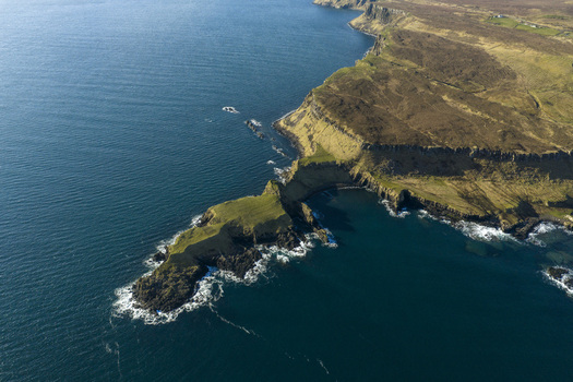 Aerial view of The Brother s Point headland with rugged cliffs and deep blue sea in Culnacnoc Scotland United Kingdom. Aerial view of The Brother s Point headland with rugged cliffs and deep blue sea in Culnacnoc Scotland United Kingdom.