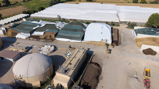 Aerial view of an agro farm biogas plant featuring large storage domes covered silage piles and agricultural machinery in Milan Lombardy Italy. Aerial view of an agro farm biogas plant featuring large storage domes covered silage piles and agricultural machinery in Milan Lombardy Italy.