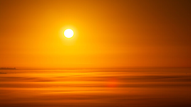 Aerial view of the sun rising above a thick layer of golden morning fog covering the landscape in Salisbury England United Kingdom. Aerial view of the sun rising above a thick layer of golden morning fog covering the landscape in Salisbury England United Kingdom.