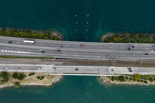 Aerial view of the bridge in Melide carrying highway traffic and railway tracks over the turquoise waters of Lake Lugano Melide Ticino Switzerland. Aerial view of the bridge in Melide carrying highway traffic and railway tracks over the turquoise waters of Lake Lugano Melide Ticino Switzerland.