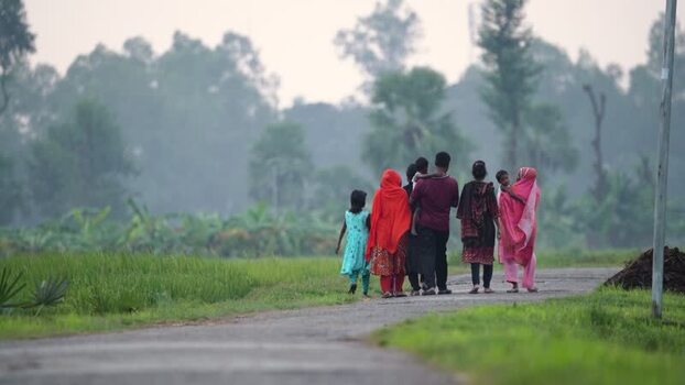 View of people walking on a rural road in Bogura Bangladesh.