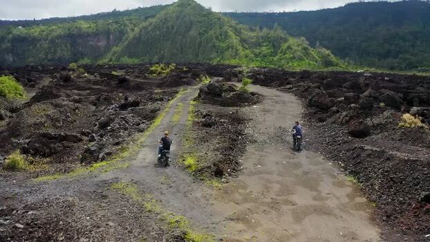 Aerial view of motorcyclists on paths through Batur volcano Indonesia.