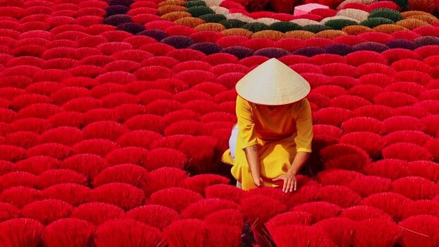 View of a person among vibrant red incense sticks Vietnam.