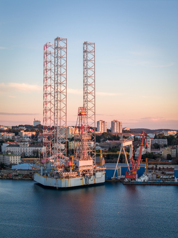 Aerial view of Uljanik Shipyard with its towering jack up rig structure industrial cranes and surrounding urban landscape at sunset in Pula Croatia. Aerial view of Uljanik Shipyard with its towering jack up rig structure industrial cranes and surrounding urban landscape at sunset in Pula Croatia.
