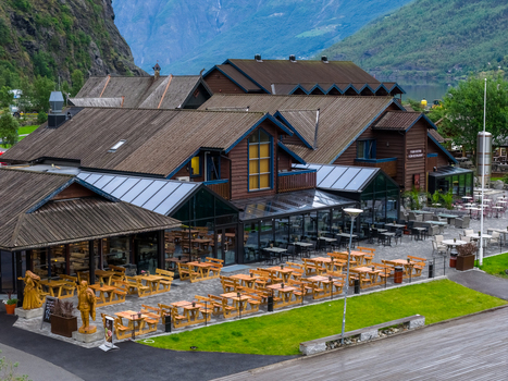 Flam Norway 19 June 2026 Aerial view of the restaurant area in Flam with wooden buildings outdoor seating and surrounding mountains in Vestland Norway. Flam Norway 19 June 2026 Aerial view of the restaurant area in Flam with wooden buildings outdoor seating and surrounding mountains in Vestland Norway.