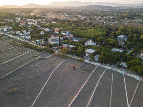 Aerial view of Velipoja Beach with its sandy coastline surrounding pine forests and residential buildings under the warm light of the golden hour in Velipoje Shkoder County Albania.