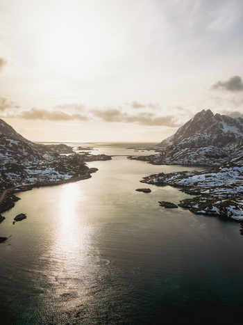 Aerial view of the bridge connecting snowy isles with dark waters reflecting the sky a scene of stark beauty and serene contrast Kåkernbrua Nordland Norway. Aerial view of the bridge connecting snowy isles with dark waters reflecting the sky a scene of stark beauty and serene contrast Kåkernbrua Nordland Norway.
