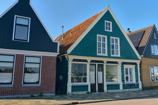 Wormerveer Netherlands 22 March 2026 View of renovated historic buildings along the Noordeinde with traditional green wooden facades and gabled roofs under a clear blue sky. Wormerveer Netherlands 22 March 2026 View of renovated historic buildings along the Noordeinde with traditional green wooden facades and gabled roofs under a clear blue sky.
