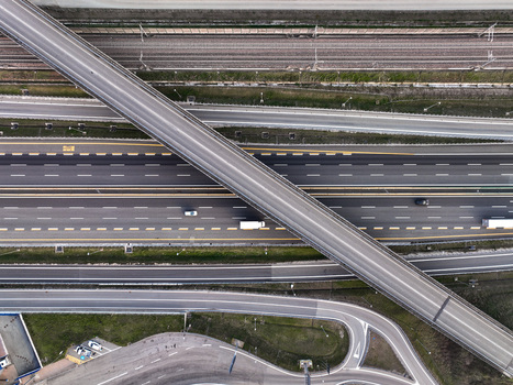 Aerial view of the Autostrada Torino Milano motorway with an overpass bridge and vehicles driving on multi lane asphalt in Borgo d Ale Piedmont Italy. Aerial view of the Autostrada Torino Milano motorway with an overpass bridge and vehicles driving on multi lane asphalt in Borgo d Ale Piedmont Italy.