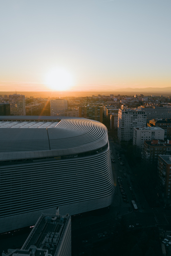Aerial view of Santiago Bernabeu stadium with its modern metallic facade at sunset surrounded by the urban cityscape of Madrid Community of Madrid Spain. Aerial view of Santiago Bernabeu stadium with its modern metallic facade at sunset surrounded by the urban cityscape of Madrid Community of Madrid Spain.