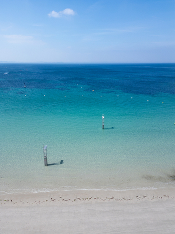 Aerial view of the turquoise waters of a sandy beach with diving platforms and a clear blue sky in Trebeurden Brittany France. Aerial view of the turquoise waters of a sandy beach with diving platforms and a clear blue sky in Trebeurden Brittany France.
