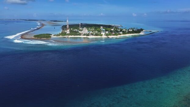 Aerial view of Thulusdhoo island and turquoise waters Maldives.