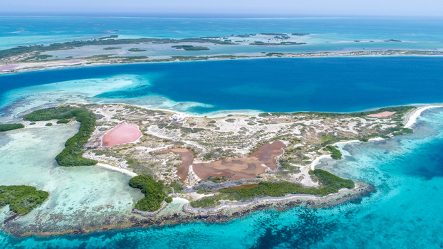 Aerial view of Los Roques archipelago featuring vibrant turquoise waters coral reefs and salt flats surrounded by lush vegetation in Los Roques Dependencias Federale Venezuela. Aerial view of Los Roques archipelago featuring vibrant turquoise waters coral reefs and salt flats surrounded by lush vegetation in Los Roques Dependencias Federale Venezuela.