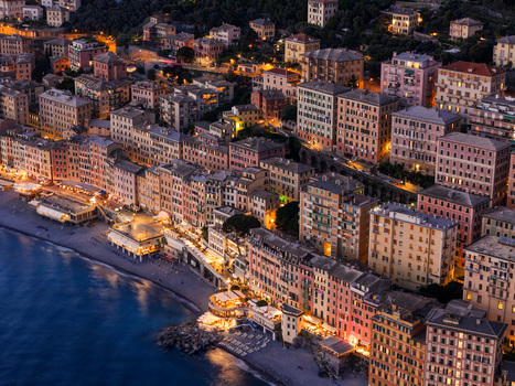 Aerial view of the illuminated colorful facades of the historic coastal town along the pebble beach at dusk Camogli Liguria Italy. Aerial view of the illuminated colorful facades of the historic coastal town along the pebble beach at dusk Camogli Liguria Italy.