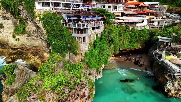 Aerial view of cliffside resort and turquoise cove Indonesia.